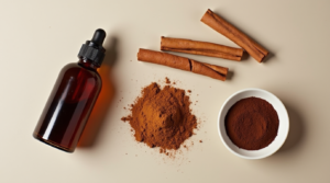 Vanilla extract, cinnamon sticks, cocoa powder, and espresso powder on a neutral background.